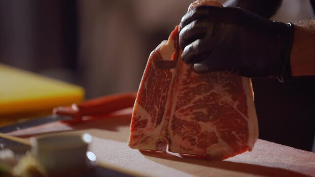 Cutting T Bone Steak on Plastic Board