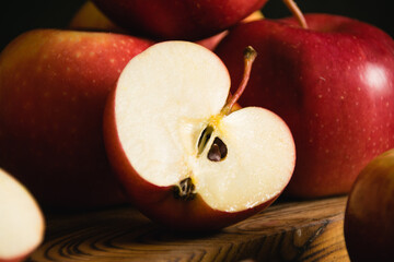 Sweet sliced apples on a wooden cutting board on a dark background, a piece of apple macro