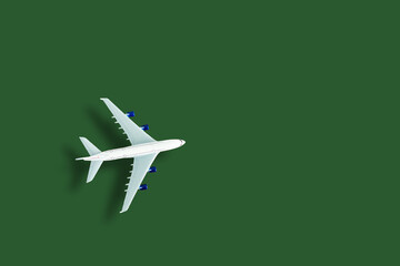 Fototapeta na wymiar Airplane model. White plane on green background. Travel vacation concept. Summer background. Flat lay, top view, copy space.