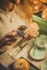 Young oman sitting in cafe and drinking turkish coffee