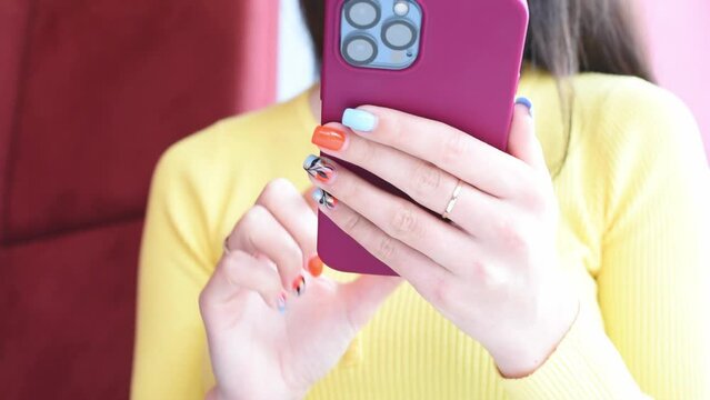 Smila, Cherkasy oblast,Ukraine -04.02.23:Girl uses Apple iphone 13pro pressing fingers. Close-up girl with smartphine sitting in social medias , typing messages. Freelancer works with iphone in cafe