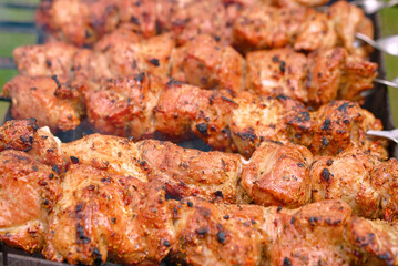 Cook meat on grill. Grilling meat with smoke. Cooking meat on brazier. Meat sticks cooked at barbecue, close up. Shish kebab cooking outdoors..