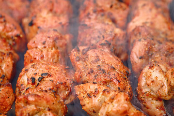 Cook meat on grill. Grilling meat with smoke. Cooking meat on brazier. Meat sticks cooked at barbecue, close up. Shish kebab cooking outdoors..
