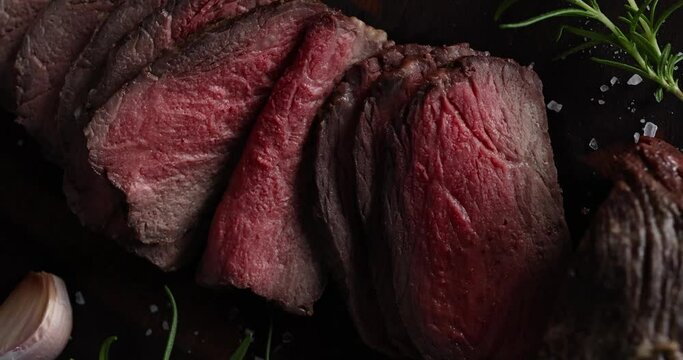 Roast beef on cutting board with salt and pepper. View from above. Macro shot meat roast beef.