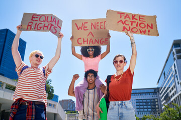 Portrait young protester friends holding equal rights signs in city
