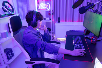 A determined online streamer creates a stream and grows an audience that can generate income through subscriptions and advertising. A contemporary, colorful, and artificially lights home office.