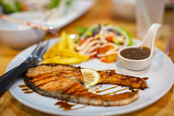 Plate of grilled salmon steak with vegetables