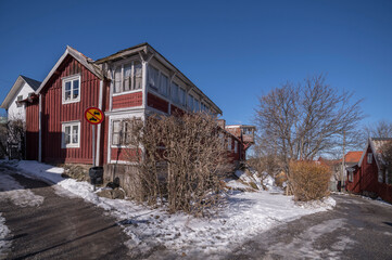 Villas and old wood family houses in the ness Kronudden at the archipelago town Vaxholm, melting snow, a sunny spring day in Stockholm