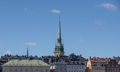 Roofs of old houses and church tower  in the old town Gamla Stan, a sunny spring day in Stockholm