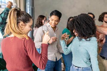 Large group of people organize a party with music and dance in a private house, multiracial friends dancing together