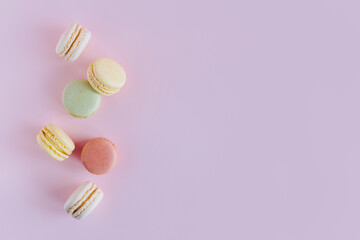 Obraz na płótnie Canvas Tasty french macarons on a pink pastel background.