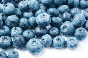 Fresh blueberries scattered on a white background.