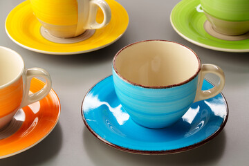 Colorful clay ceramic cups on gray background