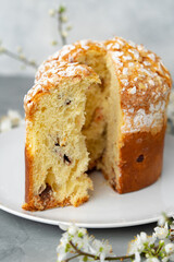 Cut Easter cake on plate decorated with spring flower branches