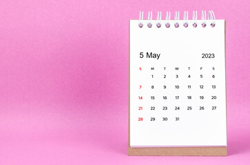 The May 2023 desk calendar on pink color background.