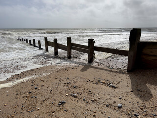Damaged breakwater groynes useless against longshore drift and storm surges caused by sea level rises and climate change.
