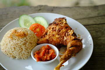 Ayam Kampung Goreng, kampong fried chicken with brown rice. Indonesian food, popular meal in Indonesia. Top view. Copy space. 