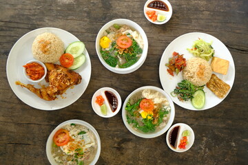 ayam goreng, mie lethek, nasi campur, kecap, sambal, acar. Indonesian dishes on a rustic wooden table. top view. Indonesian food.