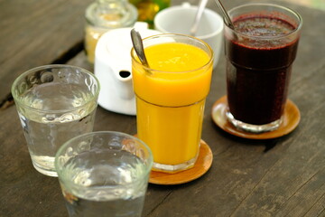 refreshing cold drinks. Mango juice, mulberry juice, water on a brown wooden table. refreshment drink. jus buah. assortment of juice. 