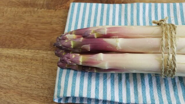 fagot d'asperges violettes, en gros plan, sur une table