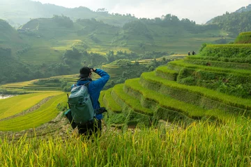 Wall murals Mu Cang Chai Tourist is standing on the viewpoint and take picture of rice terraces scenery at Mu Cang Chai in the north of Vietnam.