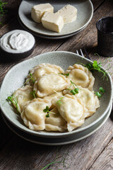 Vareniki with feta and herbs in a plate on a wooden table