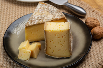 Pieces of cheese tomme de montagne or tomme de savoie made from cow milk in French Alps close up