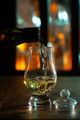 Pouring in tulip-shaped tasting glass Scotch single malt or blended whisky