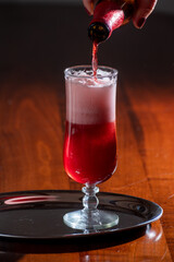 Pouring of Belgian fruity red sour cherry kriek beer in glass