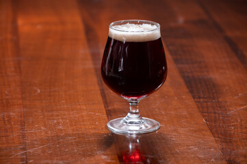 Glass of Belgian abbey red brown beer on table