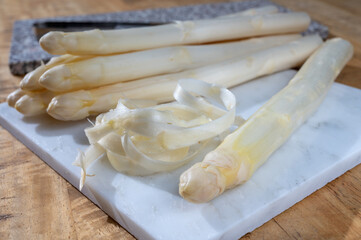 How to peel asparagus, spring season, new harvest of Dutch, German white asparagus, bunch of raw...