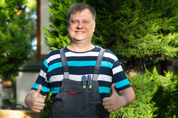 Portrait of a happy positive working man in overalls.