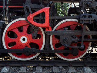 two huge red metal wheels of an old steam locomotive