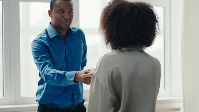 African American HR manager interviewing woman for a job, people shaking hands