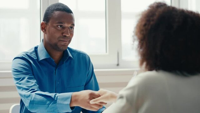 African American male hr manager shaking hand with female candidate, employment