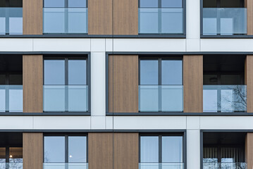 Detal na nowoczesny budynek wielorodzinny w centrum miasta. Duża ilość kondygnacji. Balkony i loggie. Słoneczna pogoda - obrazy, fototapety, plakaty