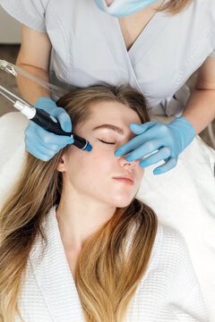 Female is getting hydrafacial vacuum face cleaning, rejuvenation, moisturizing face treatment in beauty clinic.