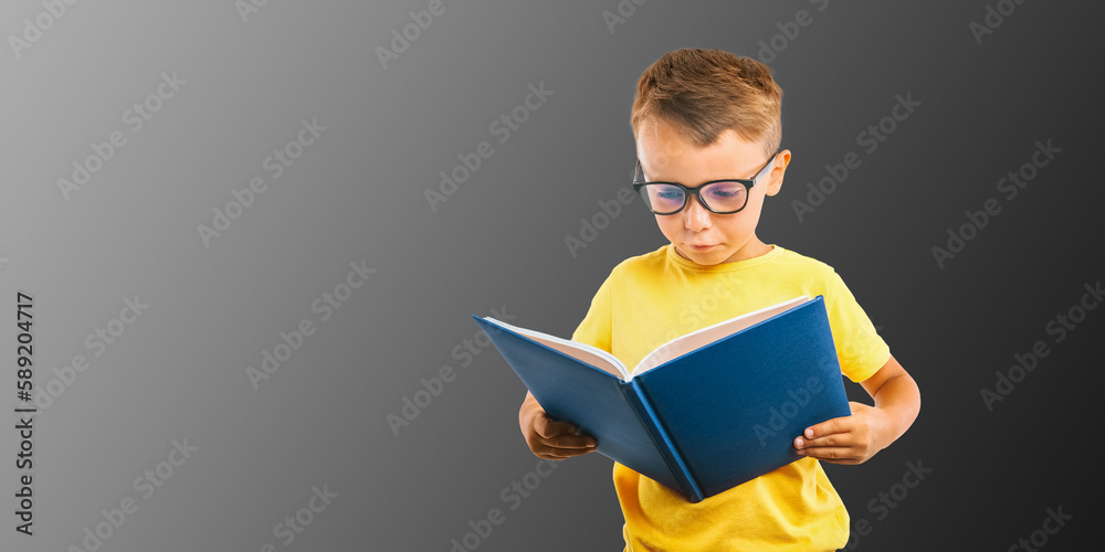 Wall mural a child reads a book against a bright wall