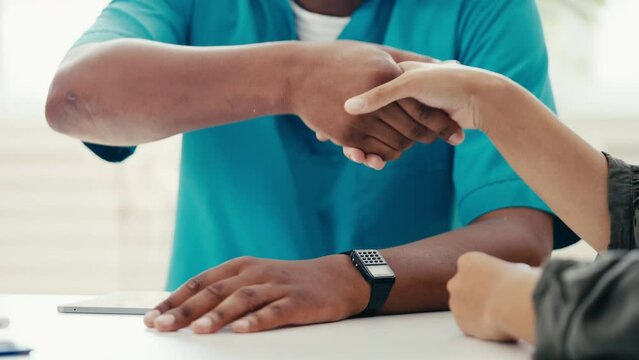 African American doctor shaking hands with patient, successful rehabilitation