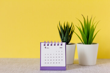 Desktop calendar for June 2023 on a yellow background.