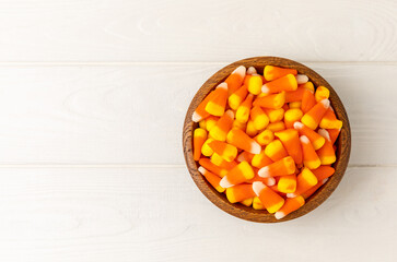 Halloween candy corn on white texture background.Classic white, orange and yellow candy corn sweets for Halloween with.copy space.Halloween holiday concept with candy corn and jack o lantern.