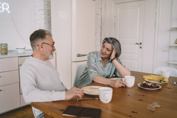 Obraz premium Senior couple having breakfast in kitchen