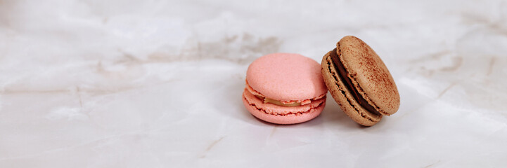 Two macarons lie on a white surface. Background for the confectionery menu. Banner for website...