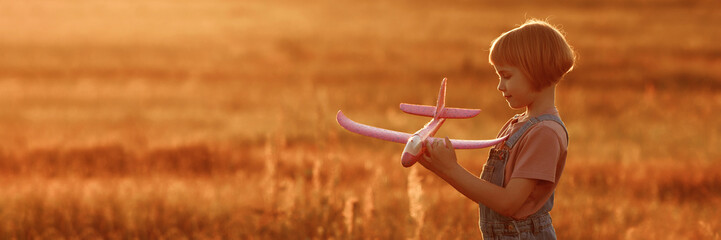 The girl runs across the summer field and launches a toy plane into the sky. A child plays aviator...