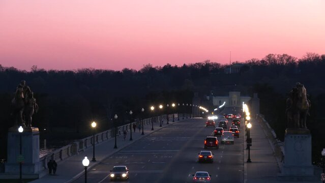 Cars driving across the Arlington Memorial Bridge towards Arlington National cemetery from Washington DC into Virginia at sunset