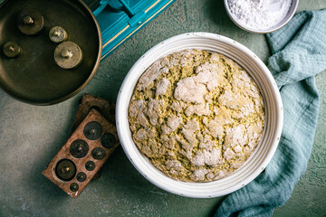 Homemade spelt bread with herbs and wild garlic, process of raising dough in a special basket