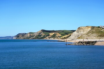 View looking West across the breakwater towards the beach and cliffs of the Jurassic Coast, West Bay, Dorset, UK, Europe