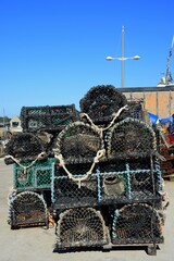 Collection of lobster pots stacked along the harbourside, West Bay, Dorset, UK, Europe