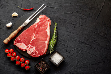raw T-bone steak on stone background with copy space for your text