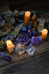 Candles, gemstones, floral cleansing bundles on wooden dark table. healing Crystal ritual, Witchcraft, Esoteric spiritual practice. wiccan magic for relax, meditation, calm soul. witch altar